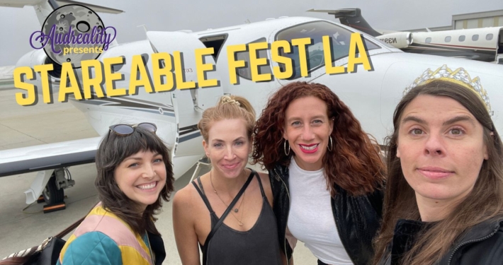 Four happy lady friends prepare to take off, smiling in front of a small jet plane.